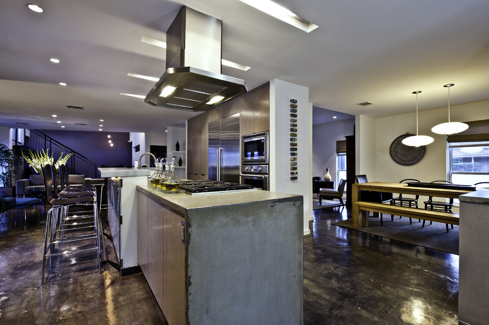 Пример оригинального дизайна: кухня-гостиная в стиле лофт с техникой из нержавеющей стали и столешницей из бетона