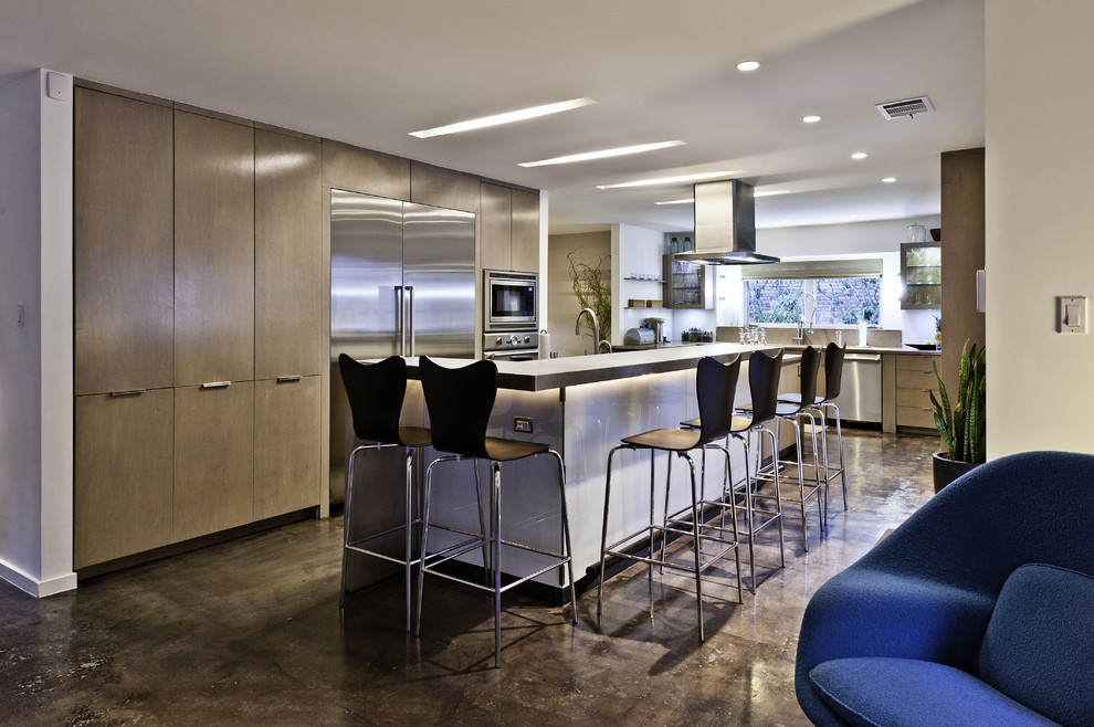 This is an example of a contemporary kitchen in Houston with stainless steel appliances, concrete worktops and brown floors.