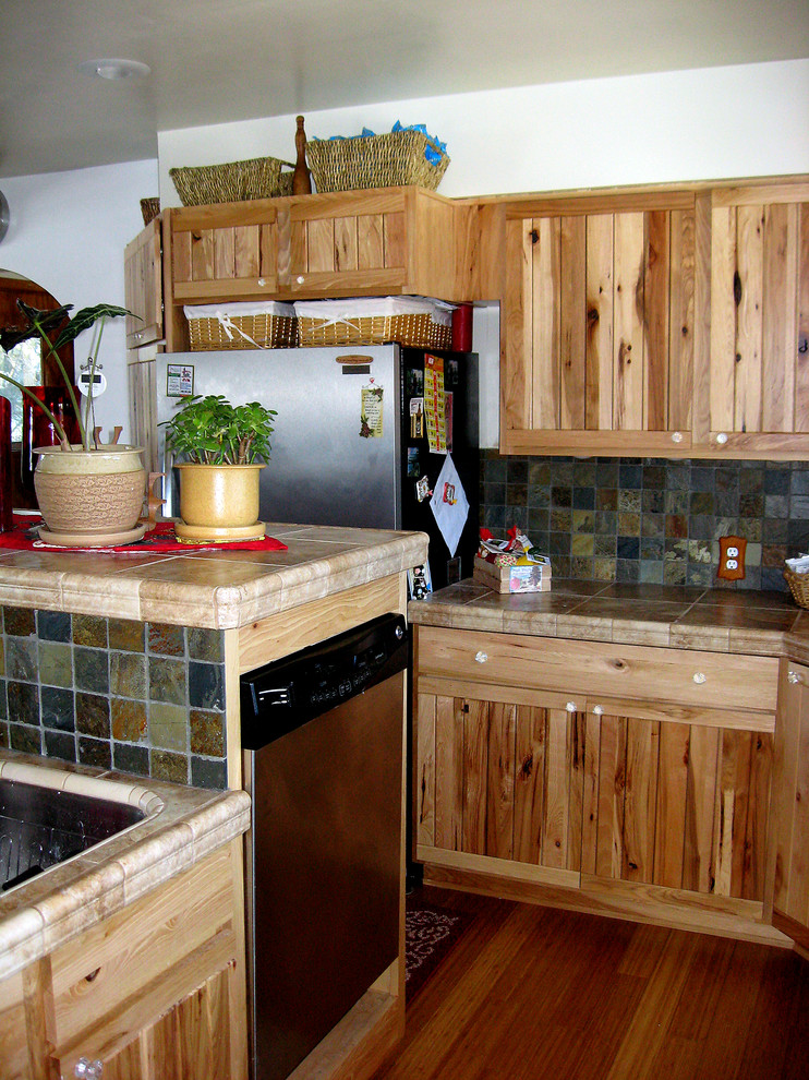 Foto de cocina rural de tamaño medio con fregadero bajoencimera, encimera de azulejos, salpicadero de azulejos de piedra, electrodomésticos de acero inoxidable, suelo de bambú y una isla