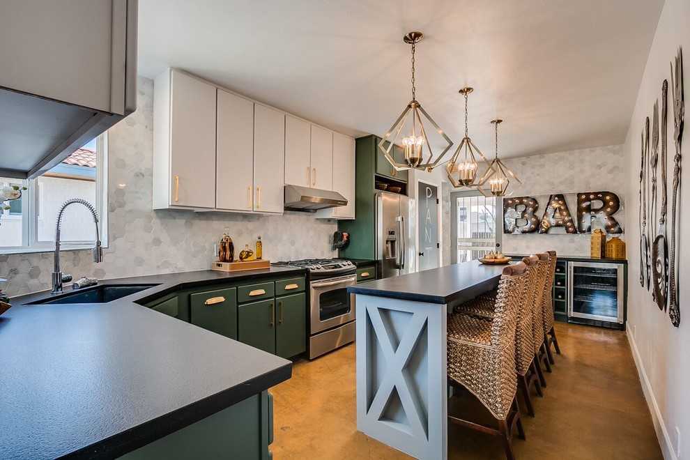 Example of a mid-sized transitional l-shaped concrete floor and brown floor enclosed kitchen design in Phoenix with an undermount sink, flat-panel cabinets, green cabinets, gray backsplash, marble backsplash, stainless steel appliances and an island