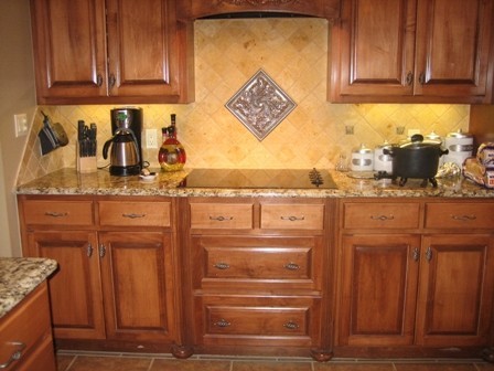 Example of a mid-sized classic l-shaped porcelain tile and beige floor enclosed kitchen design in New Orleans with an undermount sink, raised-panel cabinets, dark wood cabinets, granite countertops, multicolored backsplash, porcelain backsplash, stainless steel appliances and a peninsula