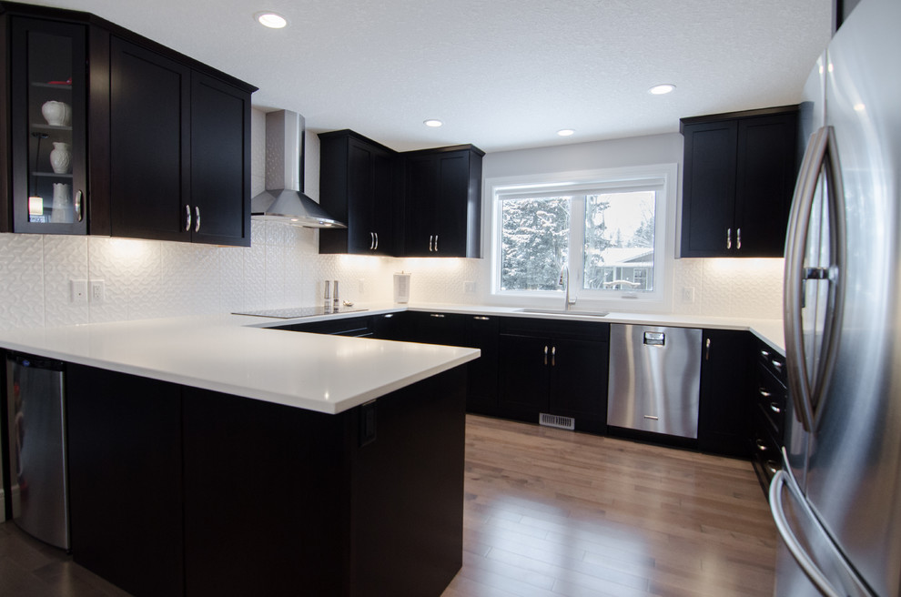 Example of a mid-sized trendy u-shaped light wood floor eat-in kitchen design with an undermount sink, beaded inset cabinets, brown cabinets, white backsplash, stainless steel appliances, a peninsula, granite countertops and subway tile backsplash