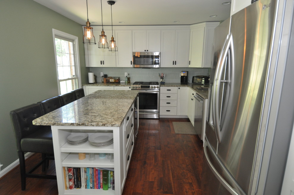 Foto di una cucina moderna di medie dimensioni con ante bianche, top in granito, paraspruzzi con piastrelle in ceramica e elettrodomestici in acciaio inossidabile