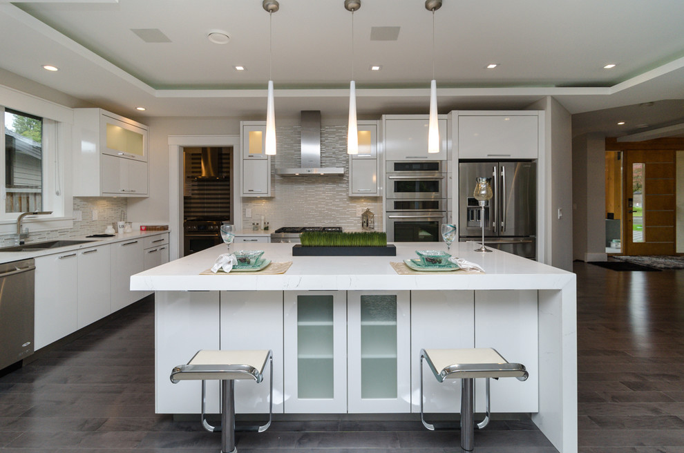 Example of a mid-sized trendy l-shaped medium tone wood floor eat-in kitchen design in Vancouver with an undermount sink, flat-panel cabinets, white cabinets, multicolored backsplash, stainless steel appliances, an island, matchstick tile backsplash and marble countertops