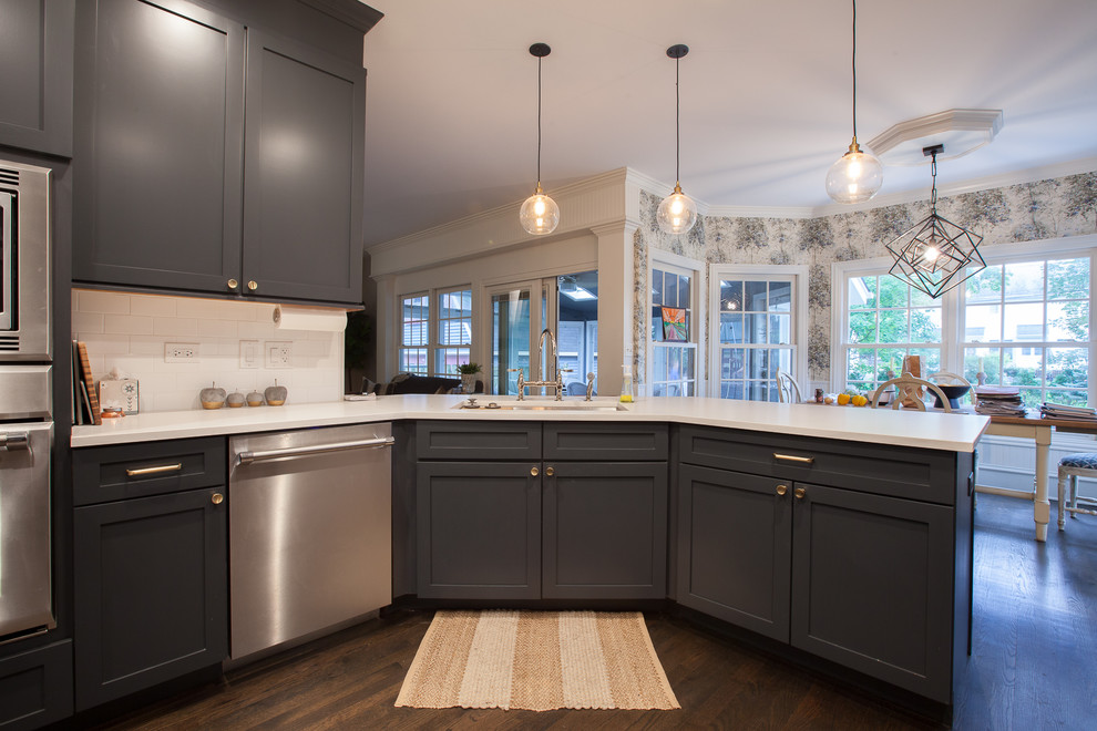 Example of a large transitional u-shaped medium tone wood floor and brown floor eat-in kitchen design in Chicago with an undermount sink, shaker cabinets, gray cabinets, quartz countertops, white backsplash, ceramic backsplash, stainless steel appliances, a peninsula and white countertops
