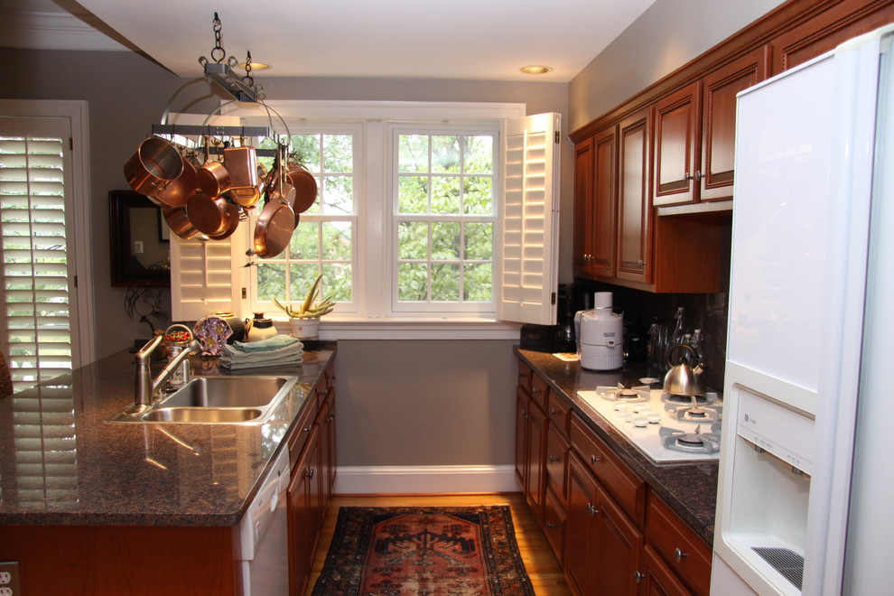 Exempel på ett mellanstort klassiskt kök, med en dubbel diskho, luckor med upphöjd panel, skåp i mörkt trä, träbänkskiva, beige stänkskydd, rostfria vitvaror och ljust trägolv
