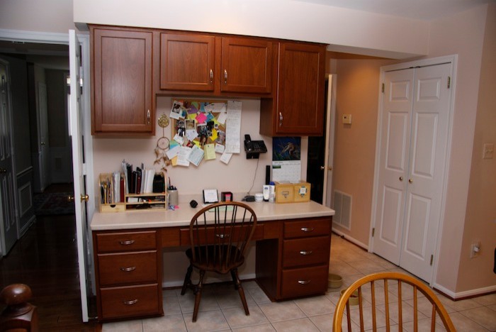 Eat-in kitchen - mid-sized traditional u-shaped light wood floor eat-in kitchen idea in DC Metro with a double-bowl sink, raised-panel cabinets, dark wood cabinets, wood countertops, beige backsplash, stainless steel appliances and no island