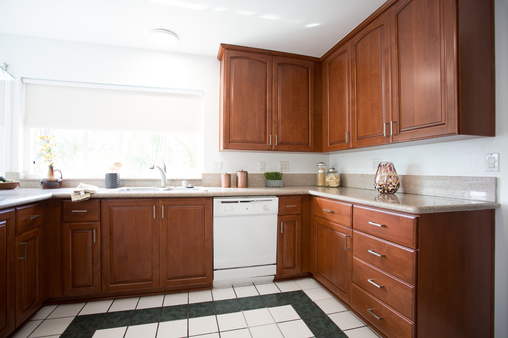 Foto på ett mellanstort funkis u-kök, med en dubbel diskho, luckor med upphöjd panel, skåp i mellenmörkt trä, granitbänkskiva och rostfria vitvaror