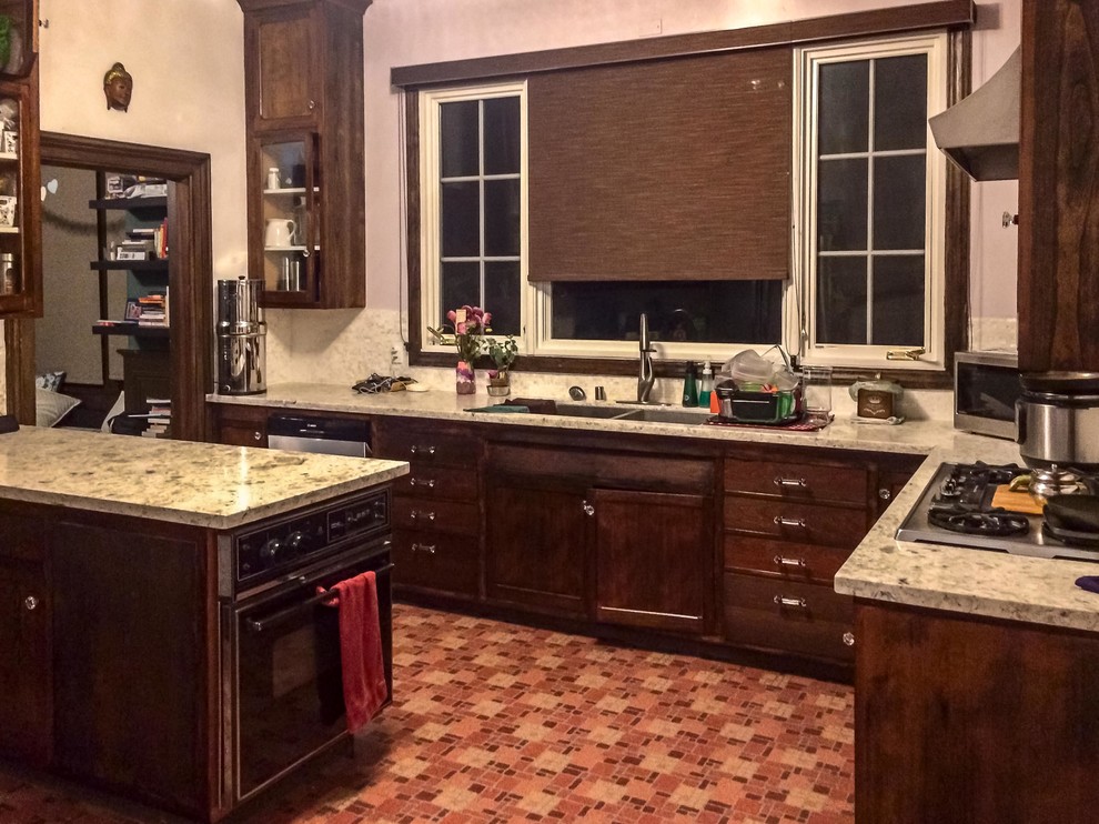 Design ideas for a medium sized traditional l-shaped kitchen/diner in San Francisco with shaker cabinets, dark wood cabinets, an island, a double-bowl sink, granite worktops, black appliances, ceramic flooring, orange floors and beige worktops.