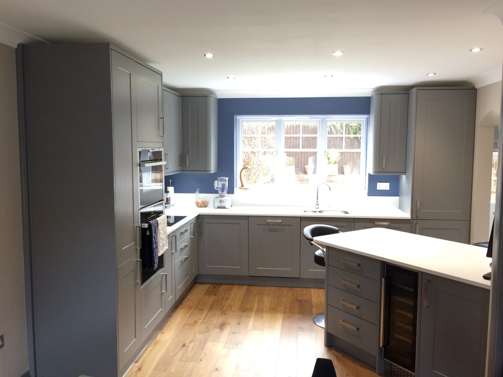 This is an example of a medium sized contemporary kitchen/diner in Essex with grey cabinets and white worktops.