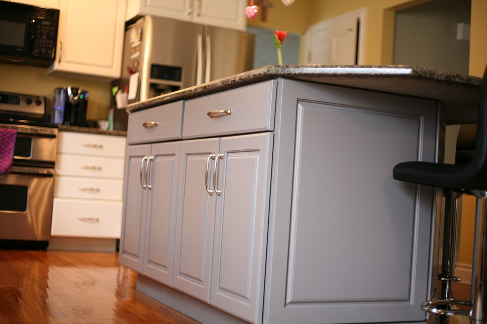 Mid-sized elegant l-shaped eat-in kitchen photo in Grand Rapids with raised-panel cabinets and an island