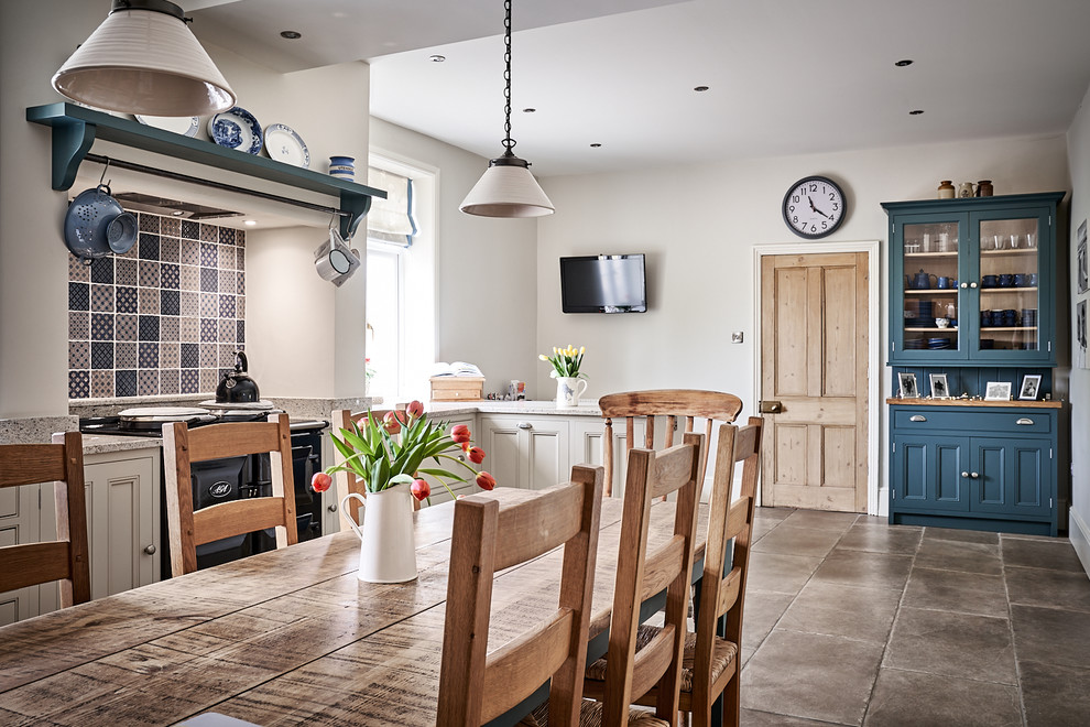 Example of a large classic ceramic tile and brown floor eat-in kitchen design in Other with a farmhouse sink, beaded inset cabinets, gray cabinets, granite countertops, blue backsplash, mosaic tile backsplash, colored appliances, no island and gray countertops
