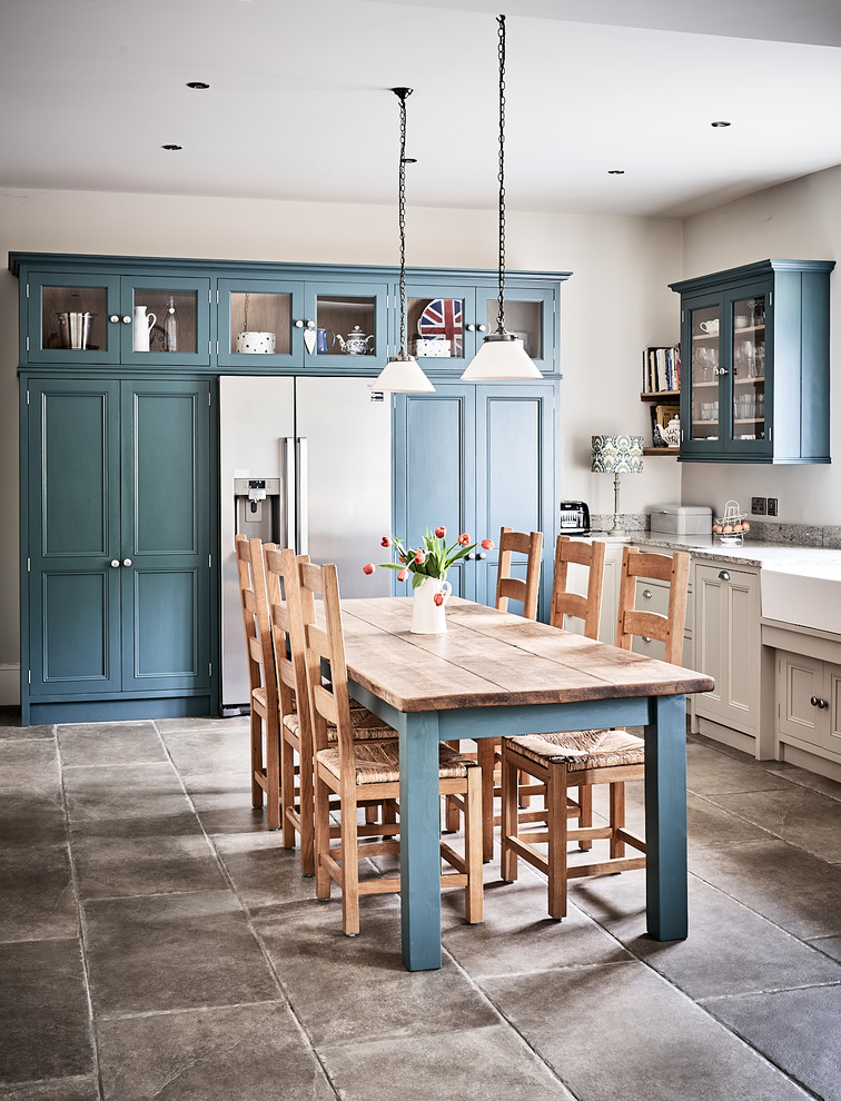 Example of a large classic ceramic tile and brown floor eat-in kitchen design in Other with a farmhouse sink, beaded inset cabinets, gray cabinets, granite countertops, blue backsplash, mosaic tile backsplash, colored appliances, no island and gray countertops
