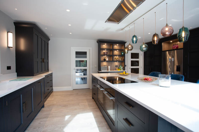 Imagen de cocina comedor contemporánea con armarios estilo shaker, puertas de armario azules, suelo vinílico, suelo gris y encimeras blancas