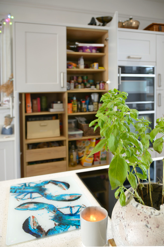 Bild på ett stort funkis vit vitt kök och matrum, med en undermonterad diskho, skåp i shakerstil, grå skåp, bänkskiva i koppar, rostfria vitvaror, mellanmörkt trägolv och en köksö