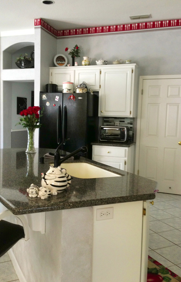 Mittelgroße Klassische Wohnküche in U-Form mit Unterbauwaschbecken, profilierten Schrankfronten, weißen Schränken, Granit-Arbeitsplatte, bunter Rückwand, schwarzen Elektrogeräten, Keramikboden und Kücheninsel in Sacramento