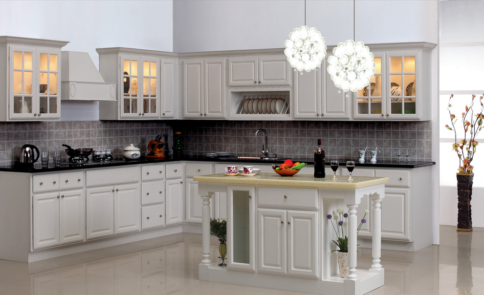 Klassisk inredning av ett mellanstort kök, med en undermonterad diskho, luckor med glaspanel, vita skåp, granitbänkskiva, grått stänkskydd, stänkskydd i porslinskakel, rostfria vitvaror, marmorgolv och en köksö