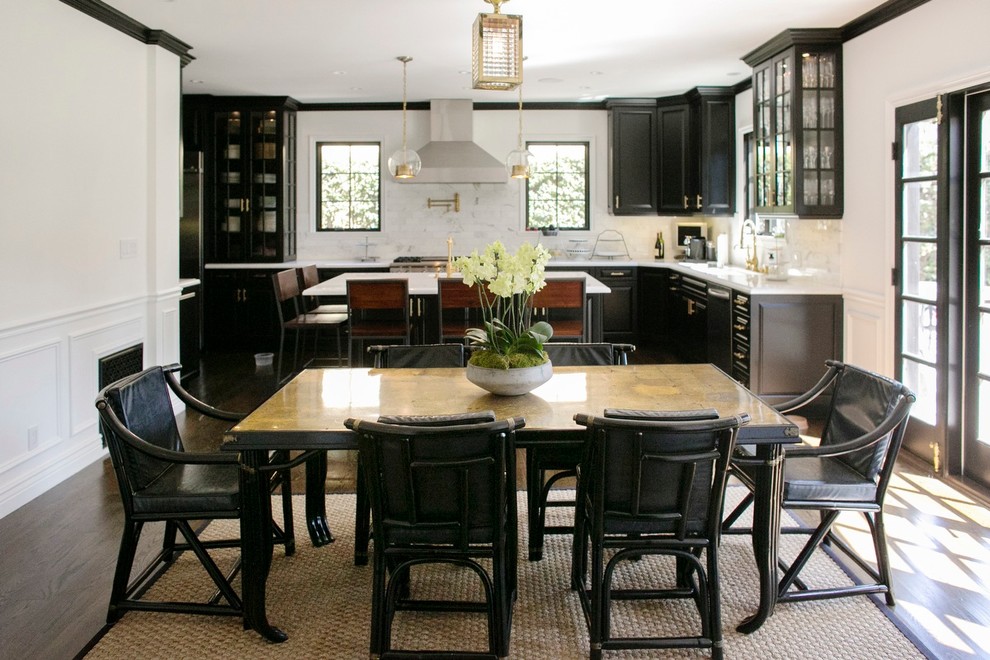 Cette photo montre une cuisine américaine chic avec des portes de placard noires, plan de travail en marbre, une crédence blanche et un électroménager de couleur.