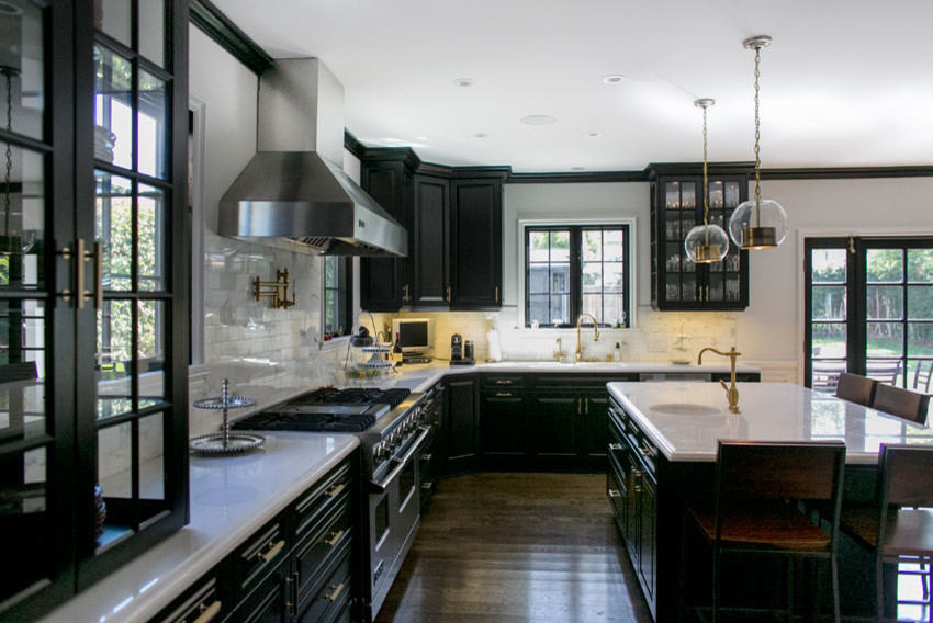Aménagement d'une cuisine américaine classique avec des portes de placard noires, plan de travail en marbre, une crédence blanche et un électroménager de couleur.
