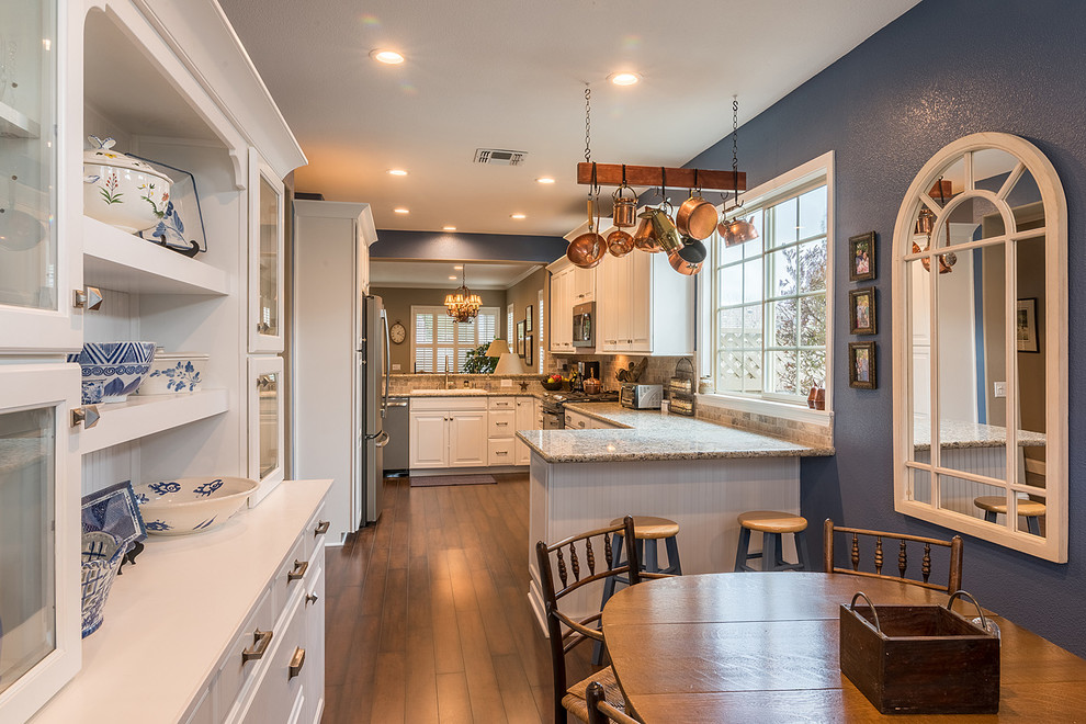Exempel på ett stort amerikanskt kök, med en rustik diskho, luckor med infälld panel, vita skåp, granitbänkskiva, flerfärgad stänkskydd, stänkskydd i stenkakel, rostfria vitvaror och mörkt trägolv