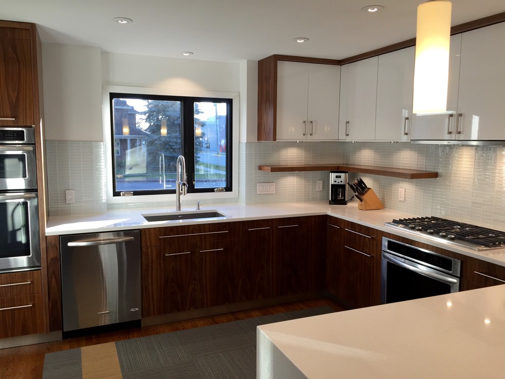 Inspiration for a large modern u-shaped medium tone wood floor eat-in kitchen remodel in Detroit with an undermount sink, flat-panel cabinets, medium tone wood cabinets, quartz countertops, white backsplash, glass tile backsplash, stainless steel appliances and an island