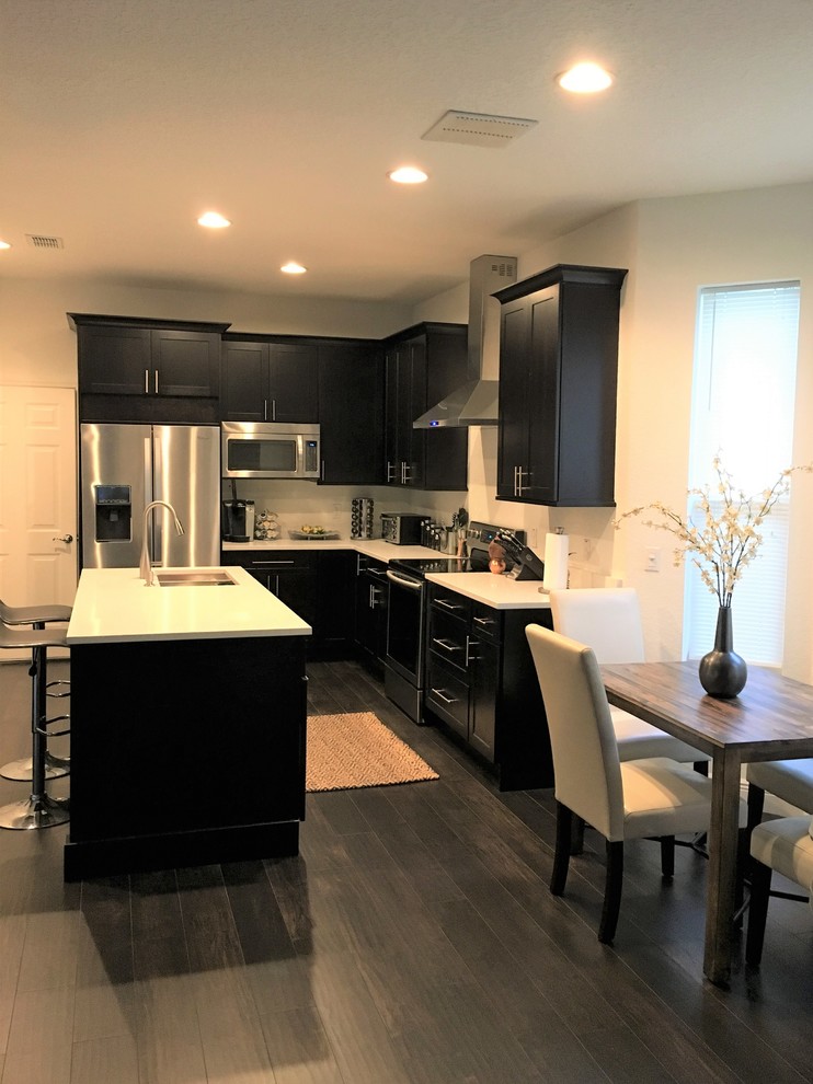 Transitional kitchen photo in Orlando with stainless steel appliances and an island