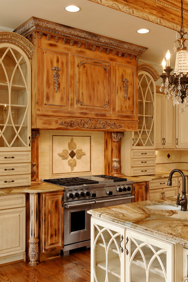 Exempel på ett stort medelhavsstil kök, med en undermonterad diskho, luckor med upphöjd panel, beige skåp, marmorbänkskiva, beige stänkskydd, stänkskydd i stenkakel, integrerade vitvaror, mellanmörkt trägolv, en köksö och brunt golv