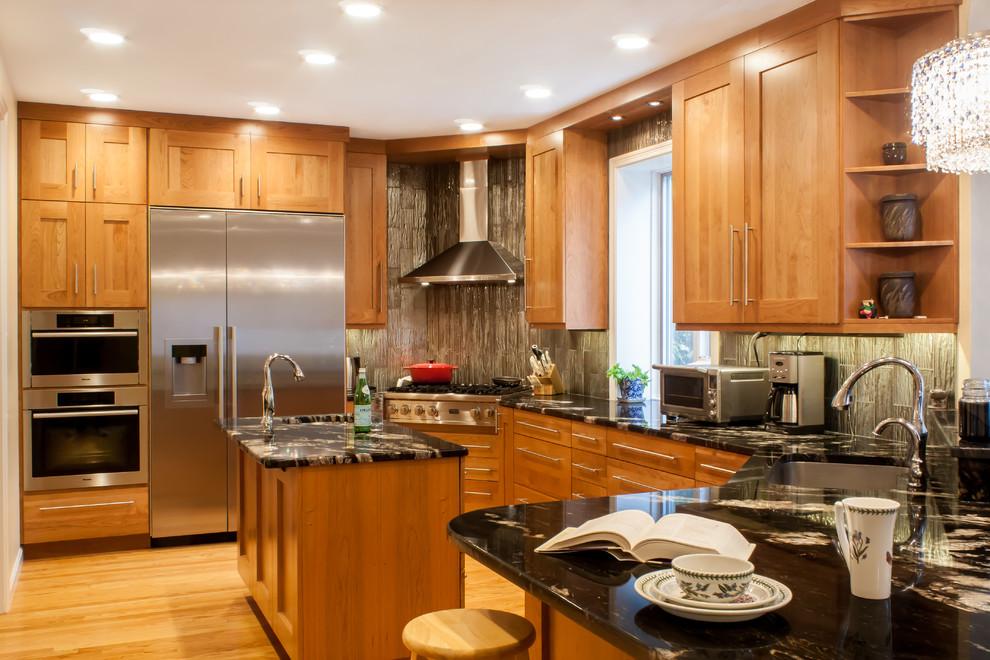 Transitional u-shaped eat-in kitchen photo in Boston with an undermount sink, recessed-panel cabinets, medium tone wood cabinets, granite countertops, metallic backsplash, glass tile backsplash and stainless steel appliances