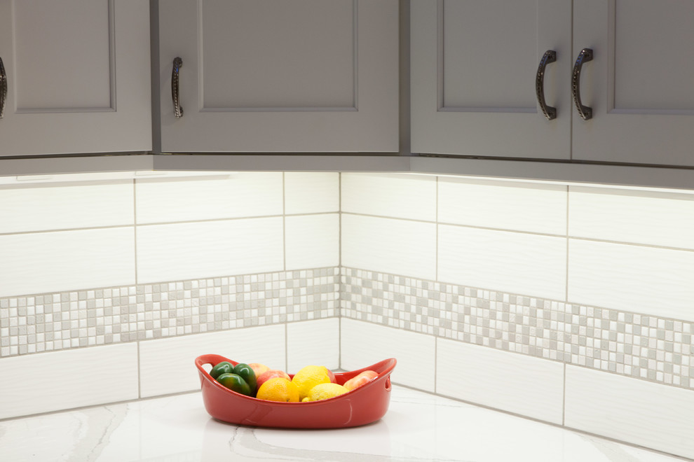 Exempel på ett klassiskt kök, med en undermonterad diskho, skåp i shakerstil, vita skåp, bänkskiva i kvarts, vitt stänkskydd, stänkskydd i keramik, ljust trägolv och en halv köksö