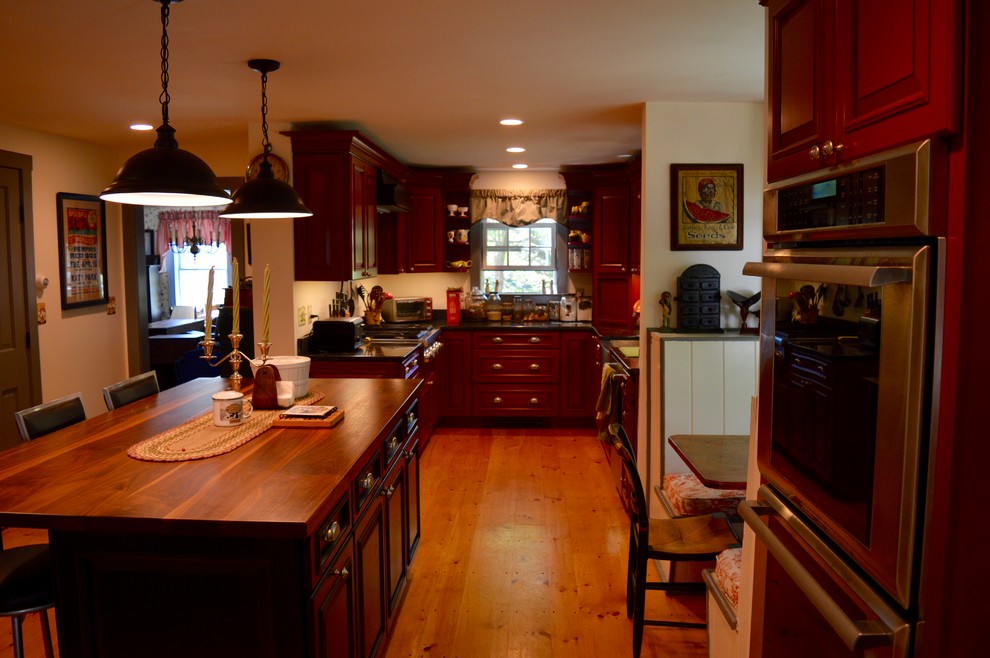Exempel på ett stort lantligt u-kök, med en rustik diskho, luckor med upphöjd panel, röda skåp, bänkskiva i koppar, rostfria vitvaror, ljust trägolv och en köksö