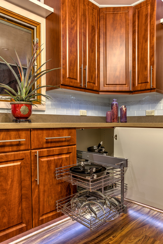 Example of a mid-sized transitional l-shaped dark wood floor enclosed kitchen design in Hawaii with an undermount sink, raised-panel cabinets, dark wood cabinets, quartz countertops, white backsplash, glass tile backsplash, white appliances and no island