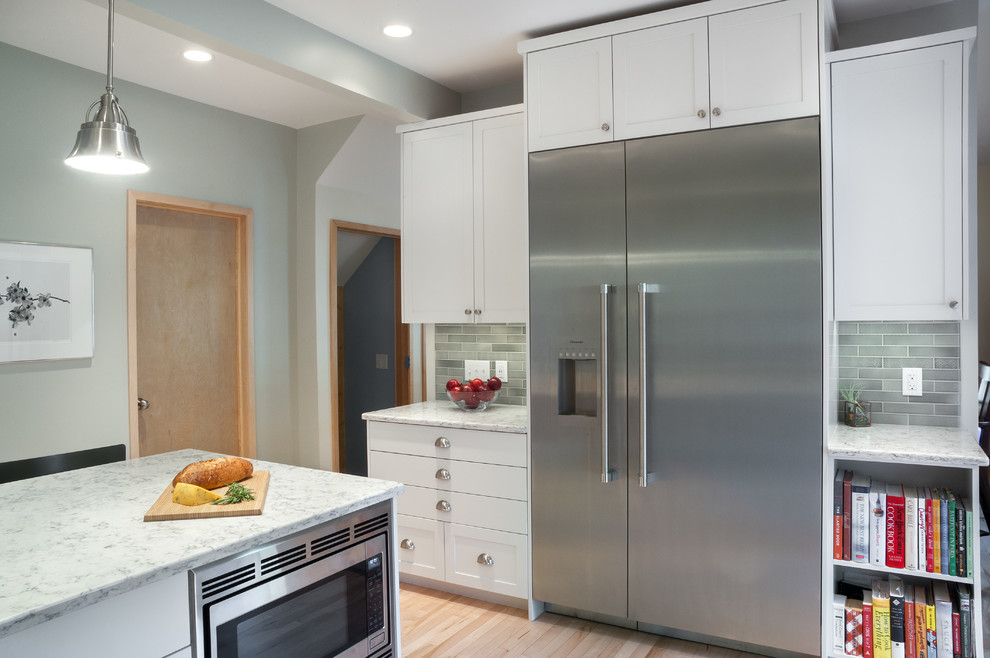 Foto di una cucina ad U design di medie dimensioni con paraspruzzi grigio, paraspruzzi con piastrelle di vetro e elettrodomestici in acciaio inossidabile