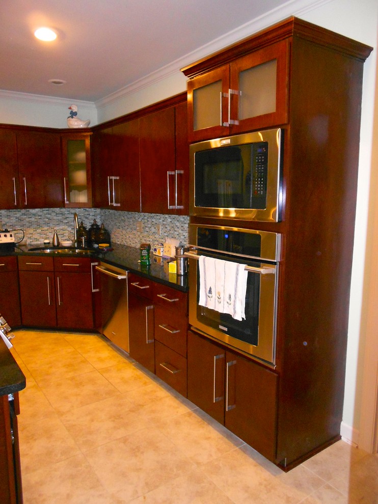 Immagine di una cucina design con lavello sottopiano, ante lisce, ante in legno scuro, top in quarzite, paraspruzzi verde e elettrodomestici in acciaio inossidabile
