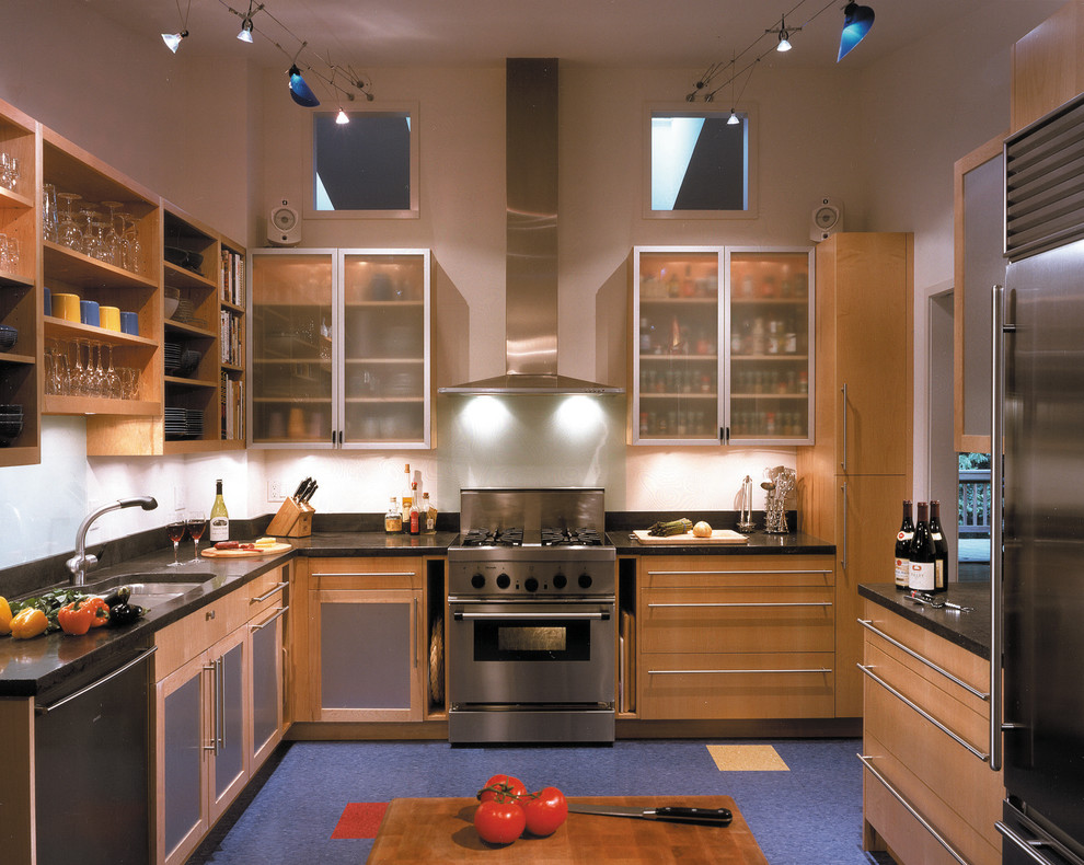 Inspiration pour une cuisine design en U et bois clair fermée avec un placard à porte vitrée et un sol bleu.