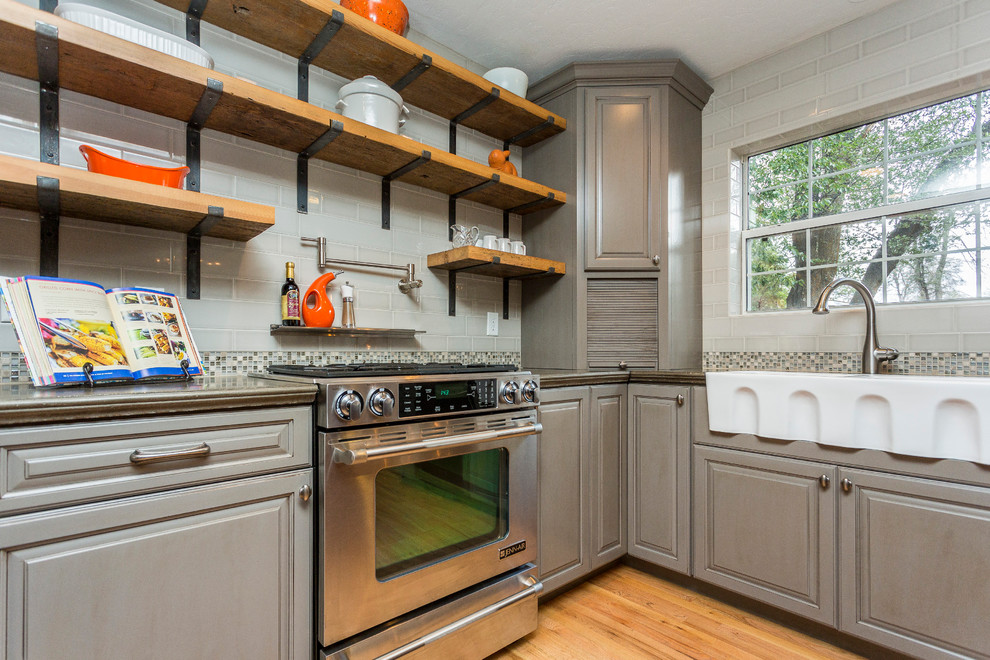 Large eclectic u-shaped light wood floor eat-in kitchen photo in Phoenix with a farmhouse sink, raised-panel cabinets, gray cabinets, concrete countertops, multicolored backsplash, glass tile backsplash, stainless steel appliances and an island