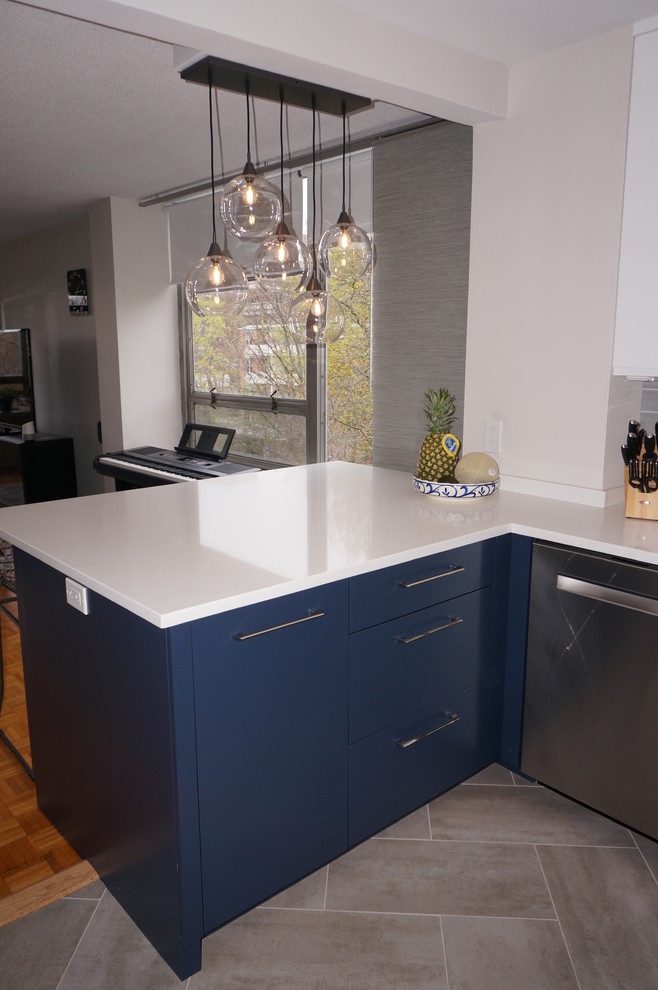 Idéer för ett litet modernt kök, med en nedsänkt diskho, släta luckor, blå skåp, bänkskiva i kvarts, grått stänkskydd, stänkskydd i glaskakel, rostfria vitvaror, en halv köksö och grått golv