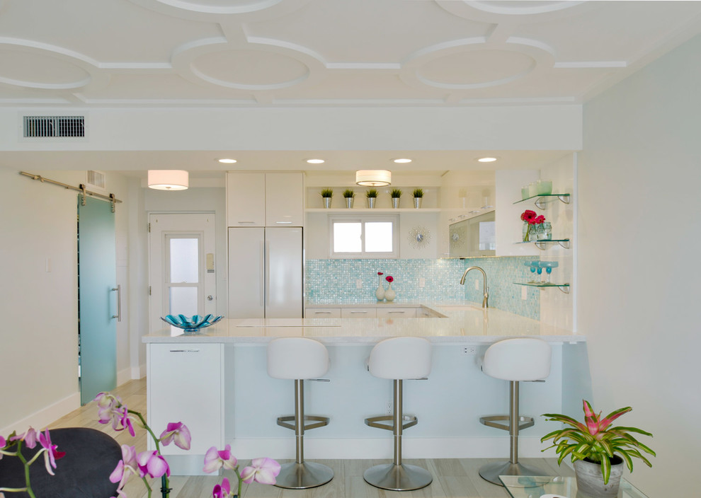 Exempel på ett mellanstort modernt kök, med en undermonterad diskho, släta luckor, vita skåp, bänkskiva i kvarts, blått stänkskydd, stänkskydd i glaskakel, vita vitvaror, klinkergolv i keramik och en halv köksö