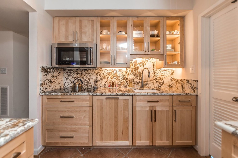 Example of a classic terra-cotta tile kitchen design in DC Metro with a single-bowl sink, shaker cabinets, light wood cabinets, granite countertops, stone slab backsplash, stainless steel appliances and a peninsula