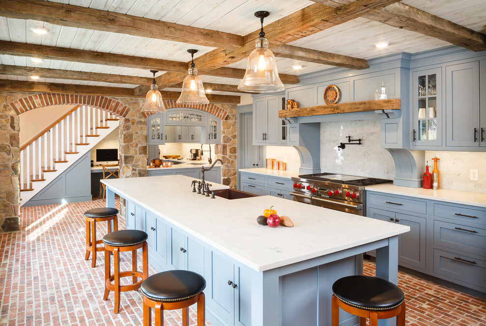 Bild på ett stort, avskilt lantligt kök, med en rustik diskho, skåp i shakerstil, blå skåp, rostfria vitvaror, tegelgolv och en köksö