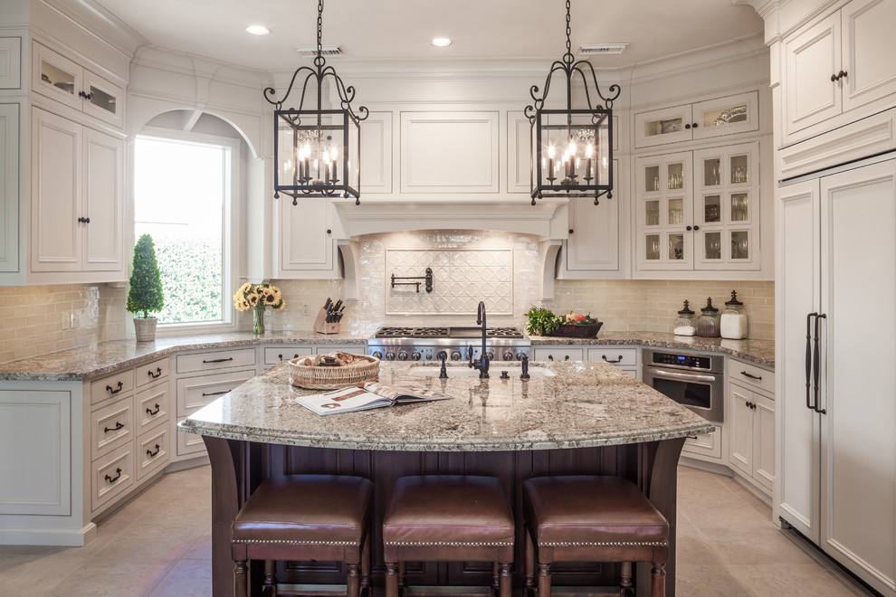 Eat-in kitchen - traditional u-shaped ceramic tile and beige floor eat-in kitchen idea in Houston with an undermount sink, beige cabinets, granite countertops, beige backsplash, stainless steel appliances, an island, multicolored countertops, ceramic backsplash and beaded inset cabinets