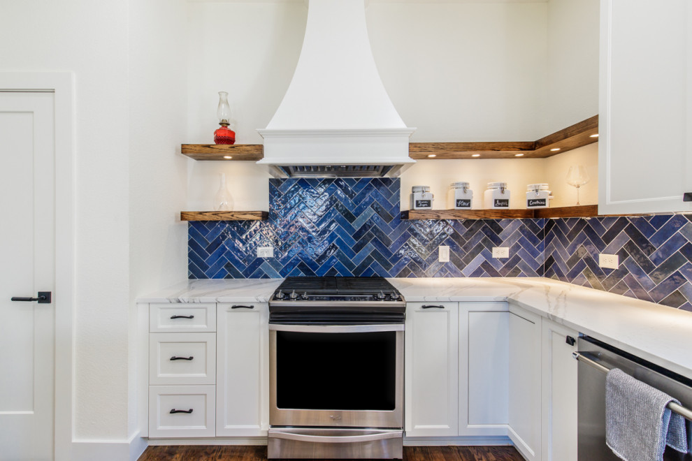 Idéer för mellanstora funkis vitt kök, med luckor med infälld panel, vita skåp, marmorbänkskiva, blått stänkskydd, stänkskydd i keramik, rostfria vitvaror och en köksö