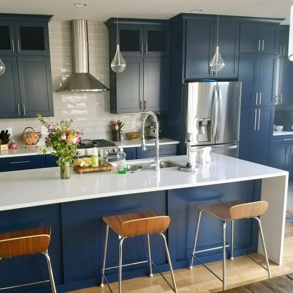 Ispirazione per una cucina moderna di medie dimensioni con lavello stile country, ante blu, top in quarzite, paraspruzzi bianco, elettrodomestici in acciaio inossidabile, parquet chiaro, pavimento marrone e top bianco