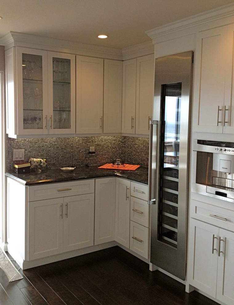 Inredning av ett modernt mellanstort kök, med en undermonterad diskho, skåp i shakerstil, vita skåp, granitbänkskiva, flerfärgad stänkskydd, stänkskydd i glaskakel, rostfria vitvaror, mörkt trägolv och en köksö