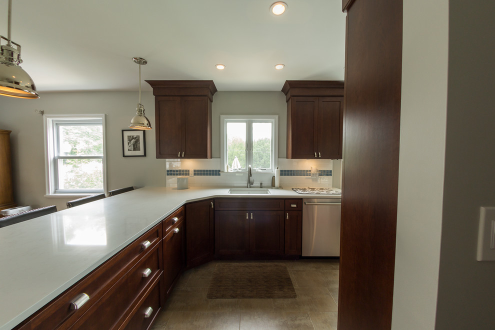 Mid-sized trendy l-shaped eat-in kitchen photo in New York with an undermount sink, flat-panel cabinets, medium tone wood cabinets, quartz countertops, white backsplash, glass tile backsplash and stainless steel appliances