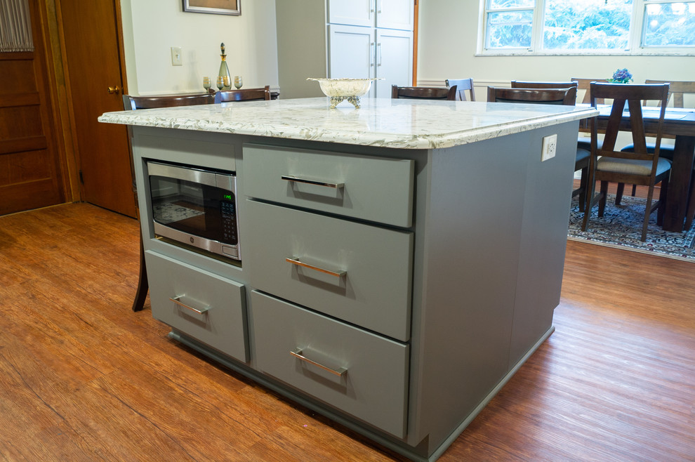 Medium sized classic l-shaped kitchen/diner in Columbus with a submerged sink, shaker cabinets, engineered stone countertops, stainless steel appliances and an island.