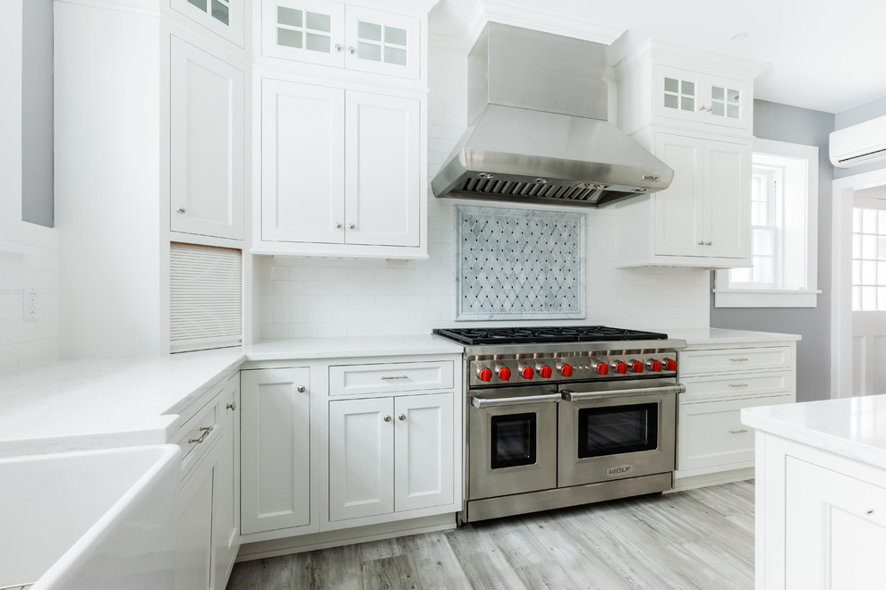 Bild på ett mellanstort vintage grå grått l-kök, med en rustik diskho, skåp i shakerstil, vita skåp, bänkskiva i kvarts, vitt stänkskydd, stänkskydd i keramik, rostfria vitvaror, klinkergolv i porslin, en köksö och grått golv