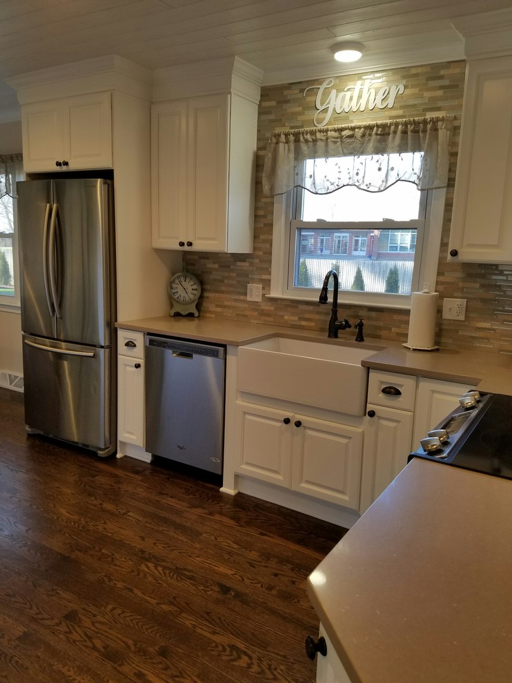 Example of a mid-sized country galley medium tone wood floor eat-in kitchen design in Bridgeport with a farmhouse sink, raised-panel cabinets, white cabinets, quartzite countertops, blue backsplash, glass tile backsplash, black appliances and an island