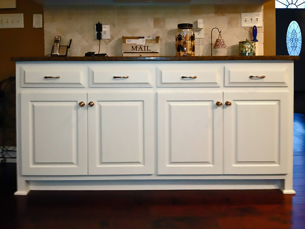 Klassische Wohnküche in L-Form mit Doppelwaschbecken, profilierten Schrankfronten, weißen Schränken, Granit-Arbeitsplatte, Küchenrückwand in Weiß, Rückwand aus Keramikfliesen und Küchengeräten aus Edelstahl in Houston