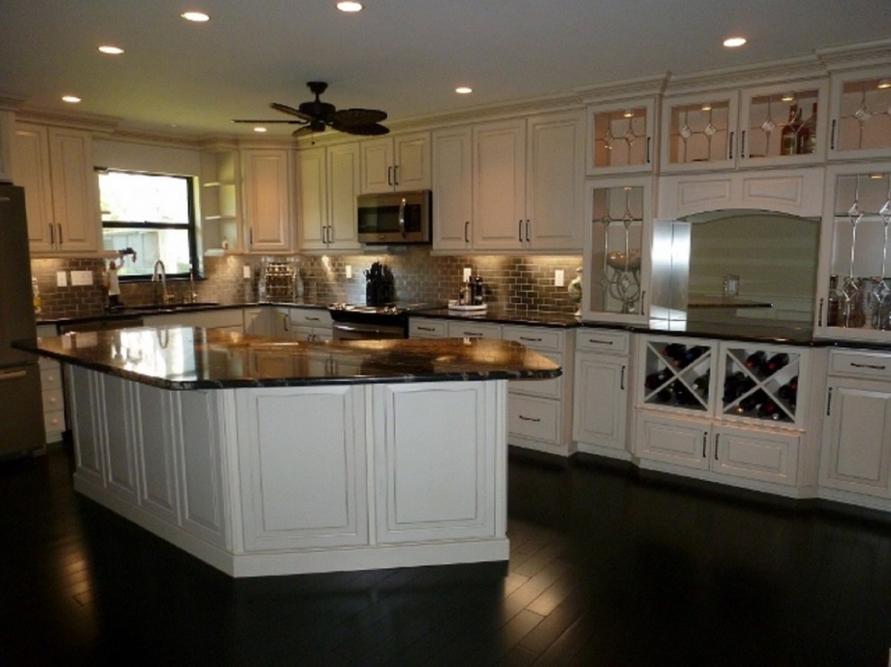 Bild på ett vintage kök, med en undermonterad diskho, luckor med infälld panel, beige skåp, granitbänkskiva, stänkskydd med metallisk yta, stänkskydd i metallkakel och rostfria vitvaror