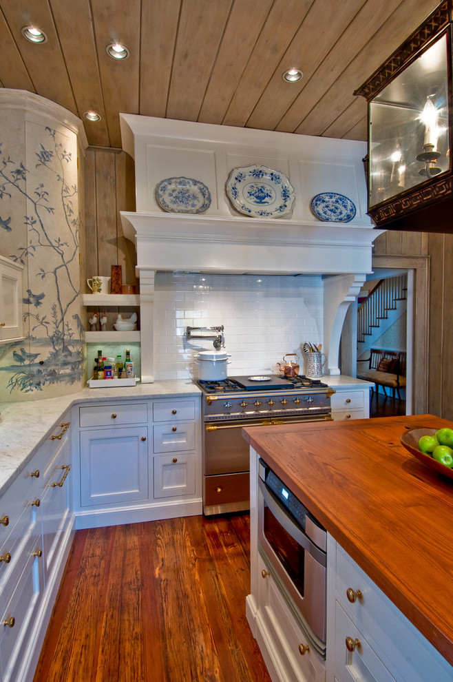 シャーロットにあるシャビーシック調のおしゃれなキッチン (サブウェイタイルのキッチンパネル、木材カウンター、シルバーの調理設備) の写真